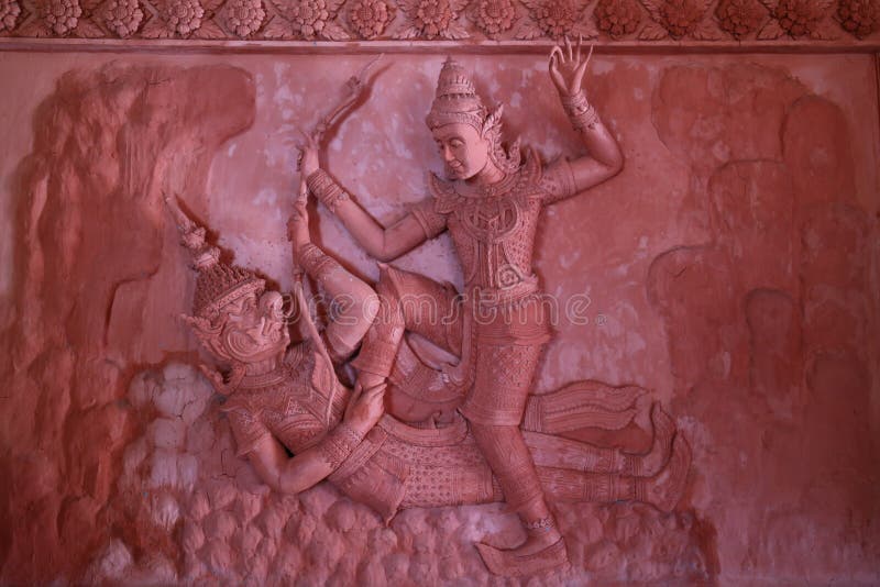 Close-up of giant holding a stick with hanuman armed sculpture w