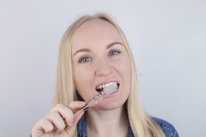 Close Up Of A Girl Brushing Teeth And Look In Front Of A Mirror Oral Hygiene In The Hands Of