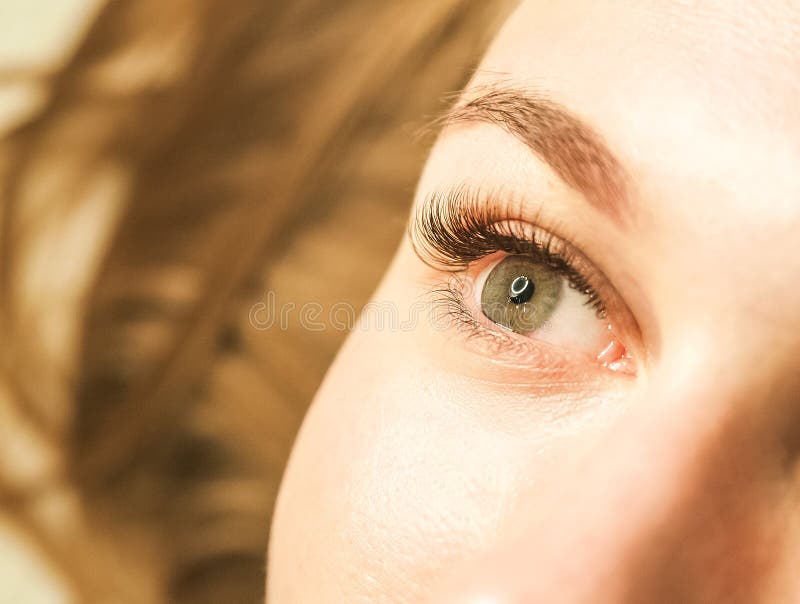 Close-up of a girl`s eye with lashes. The concept of caring for the eyes, eyelash extensions in the salon.