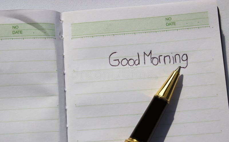 Close up greetings good morning written using a pen in a diary in detail and exclusive as encouragement in starting the day. Close up greetings good morning written using a pen in a diary in detail and exclusive as encouragement in starting the day
