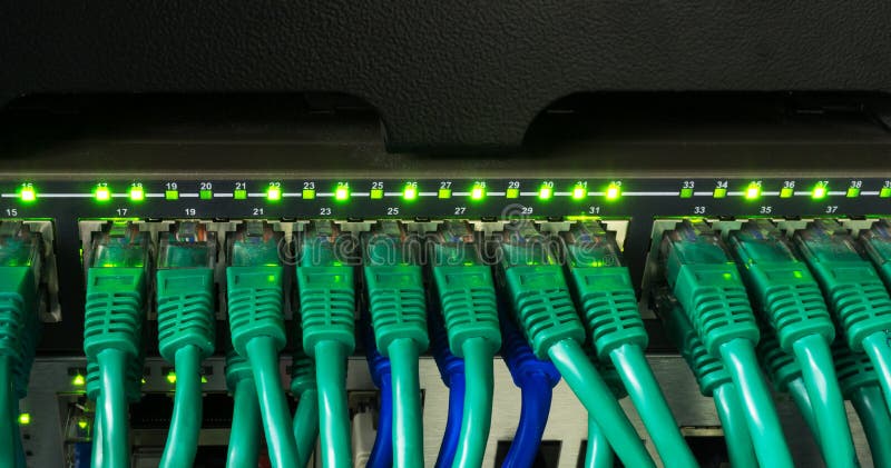 Close up of green network cables connected to switch glowing stock images
