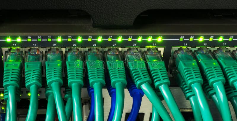 Close up of green network cables connected to switch glowing royalty free stock photo