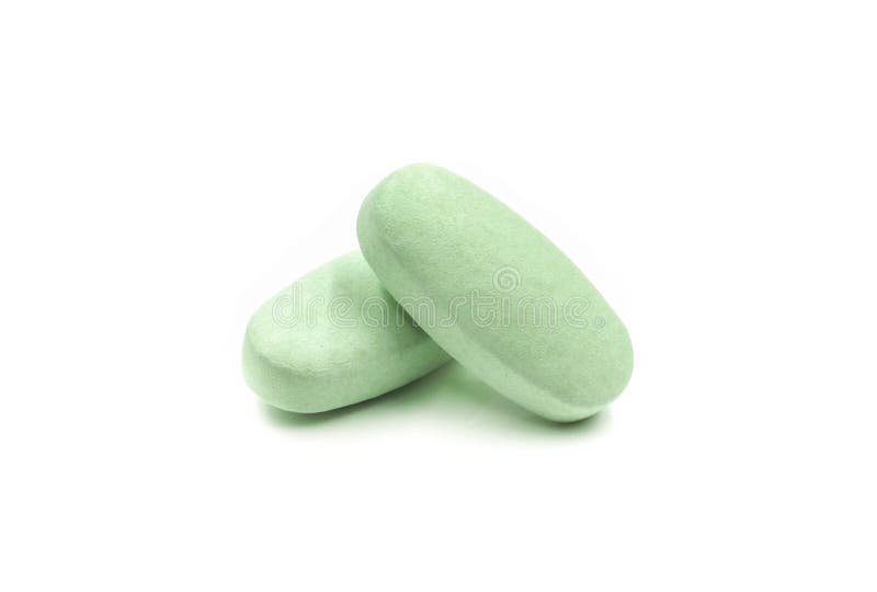 Close-up of green pills medicine, vitamin tablets isolated on white