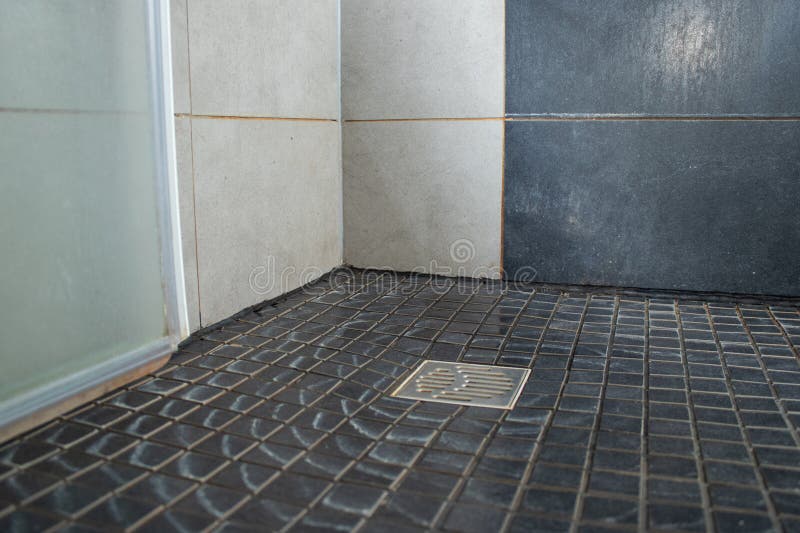Close up of grey tiles floor with limescale in the shower royalty free stock photos