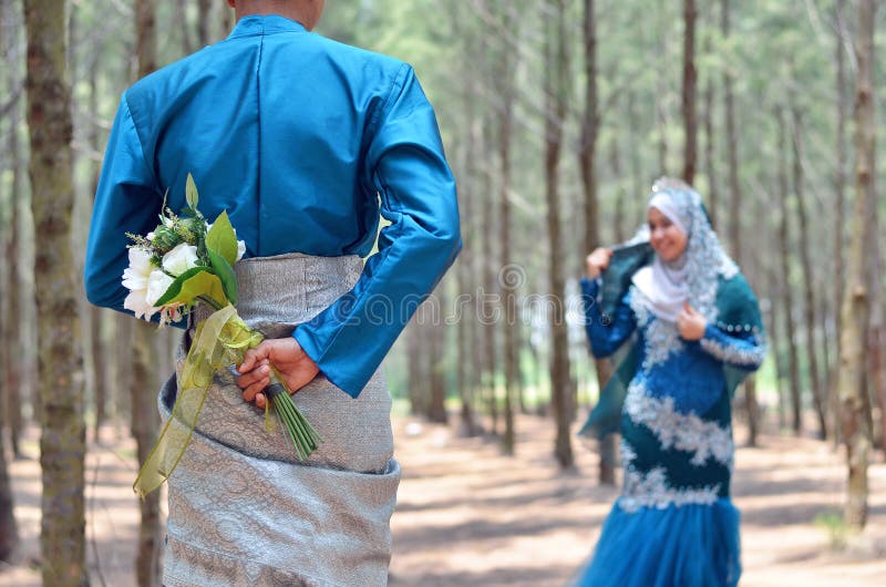 Close up of a groom holding a wedding flower bouquet looking at her bride. royalty free stock photo Close up of a groom holding a wedding flower bouquet looking at her bride. royalty free stock photo
