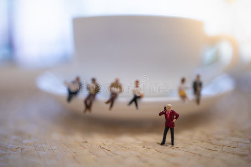 Close up of group of businessman miniature figure standing and make phone call with white cup of coffee stock image Close up of group of businessman miniature figure standing and make phone call with white cup of coffee stock image