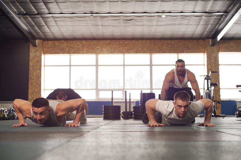 Close-up - Group of Male Muscular Friends Working Out in Gym.