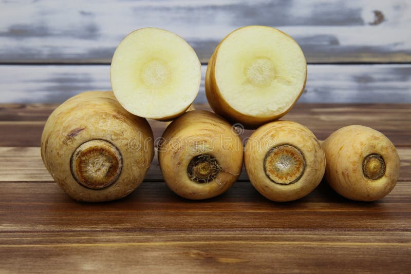 Close up of group raw isolated sliced parsnip root vegetables with wooden background stock images