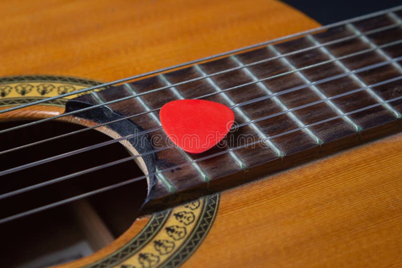 Close Up Of A Guitar Pick On The Strings Of A Classical Guitar Stock