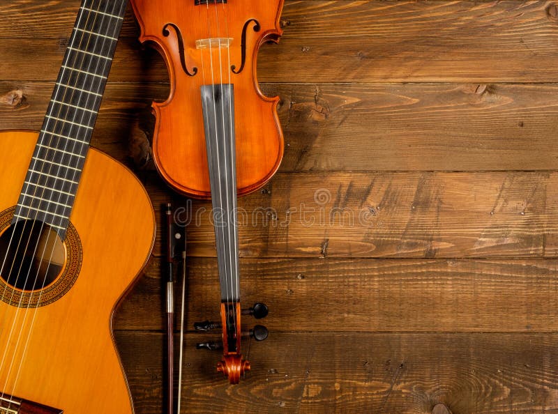 Guitar and violin in wood background