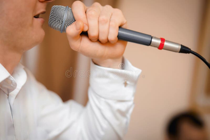 Closeup Guy Singing Into The Microphone Closeup. Profile Of