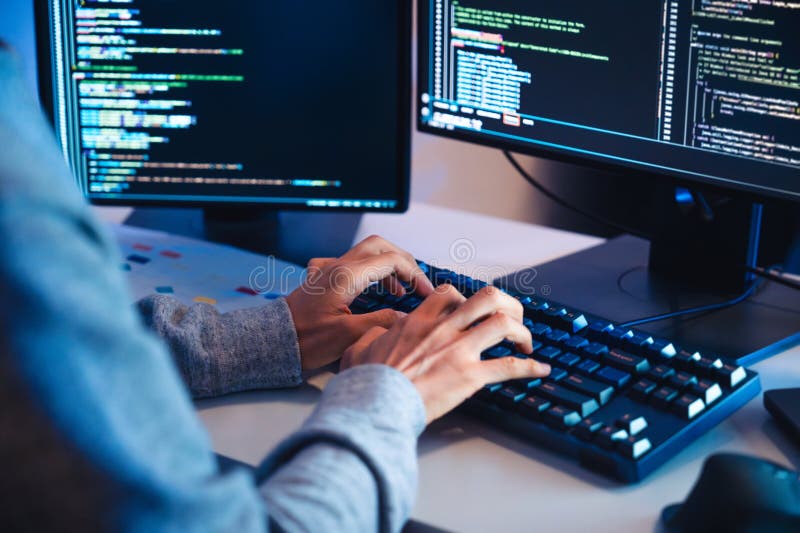 Close up hand of Asian prompt engineer develop coding app with software data sitting in front of computer monitor at office stock photography