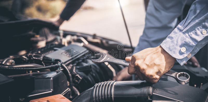 Close-up hand of auto mechanic using wrench to repair a car engine.