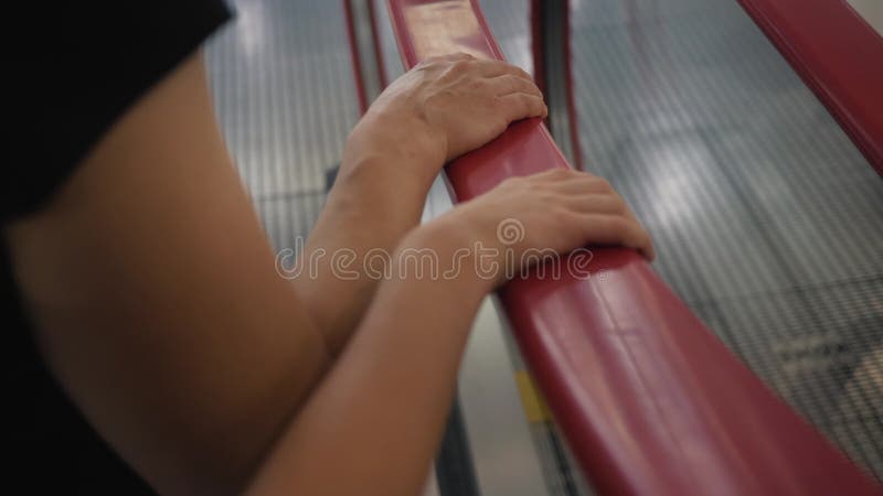 Close-up of a hand on a climbing escalator. Moving staircase