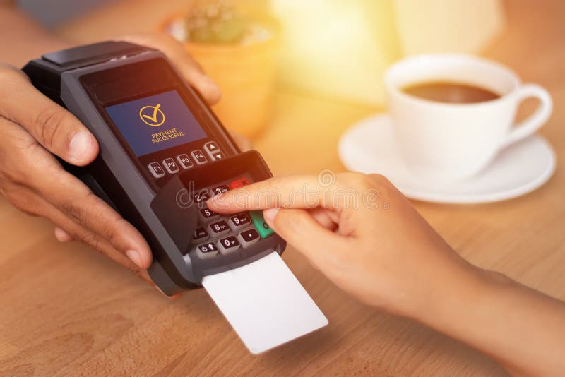 Close up of hand entering credit card pin code for security password in credit card swipe machine at point of sale terminal