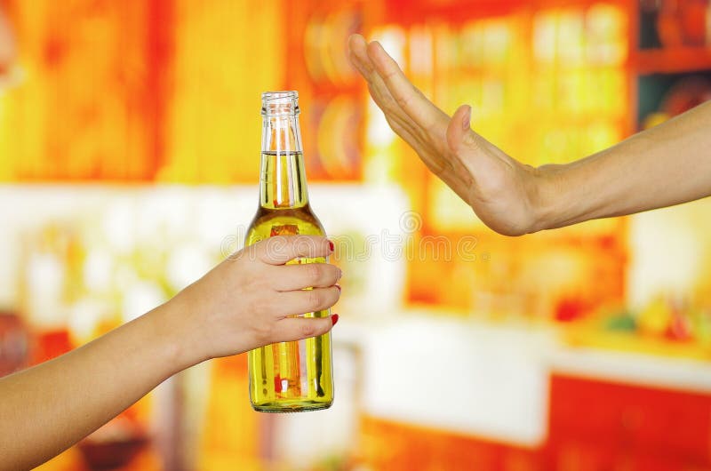Close up of a hand holding a beer and a male hand refusing it, in bar background stock photos