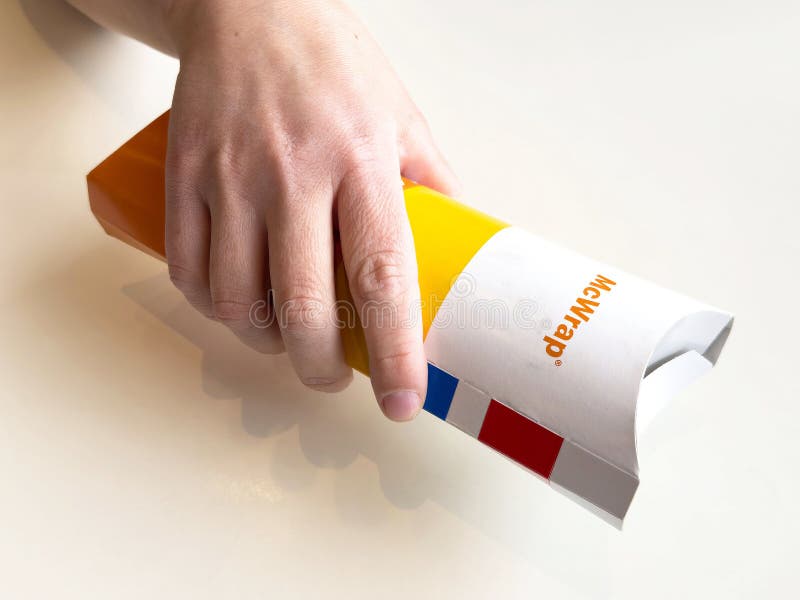 Close-up of hand holding fast food box with mcwrap label stock photo