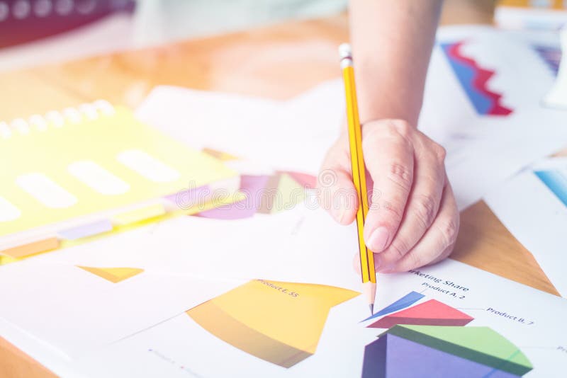 Close up hand holding pen pointing to discuss the graph up and down of economy and work on pape royalty free stock image