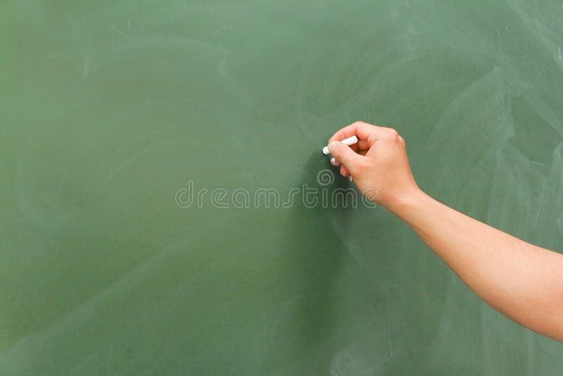 Close up ,Hand holding white chalk pointing something on chalkboard,Copy space for your text stock photo