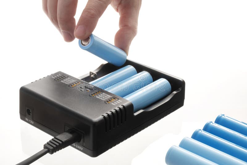 Close up of hand inserting 18650 lithium battery into charger stock photo
