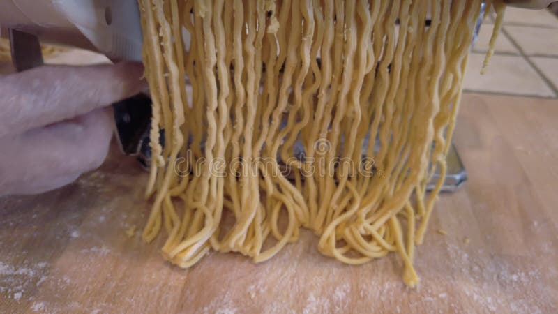 Close up hand making homemade uncooked long pasta tonnarelli like spaghetti stock footage