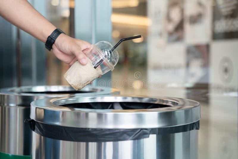 Closeup Hand of a Man Throwing Empty Plastic Coffee Mugs Cup in
