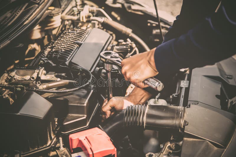 Close up hand of mechanic hands using wrench to repair a car engine.