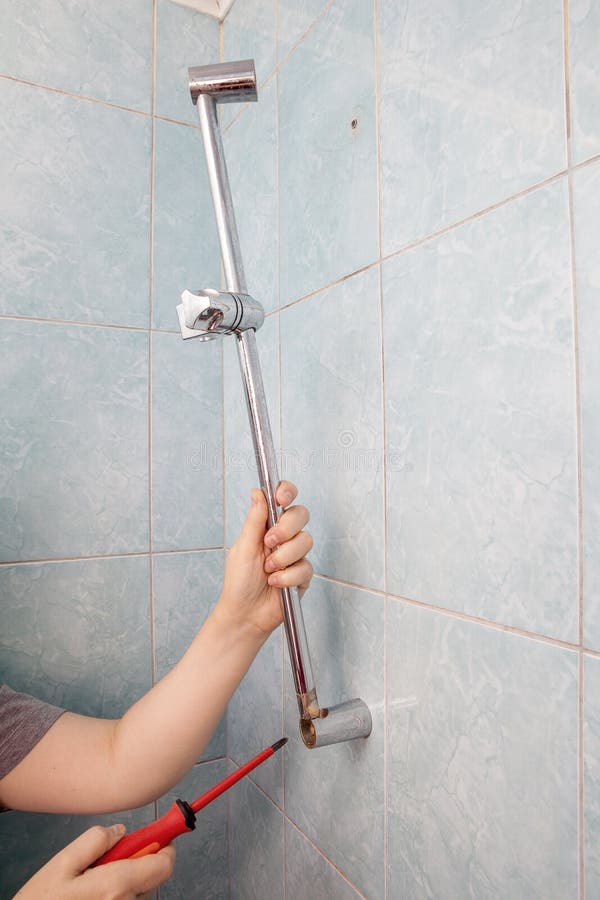 Closeup of Hand Removed Broken Handheld Shower Rail Slider Bar. Stock
