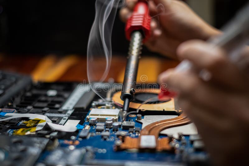 Hand Technician Repairing Broken Laptop Notebook Computer with Electric