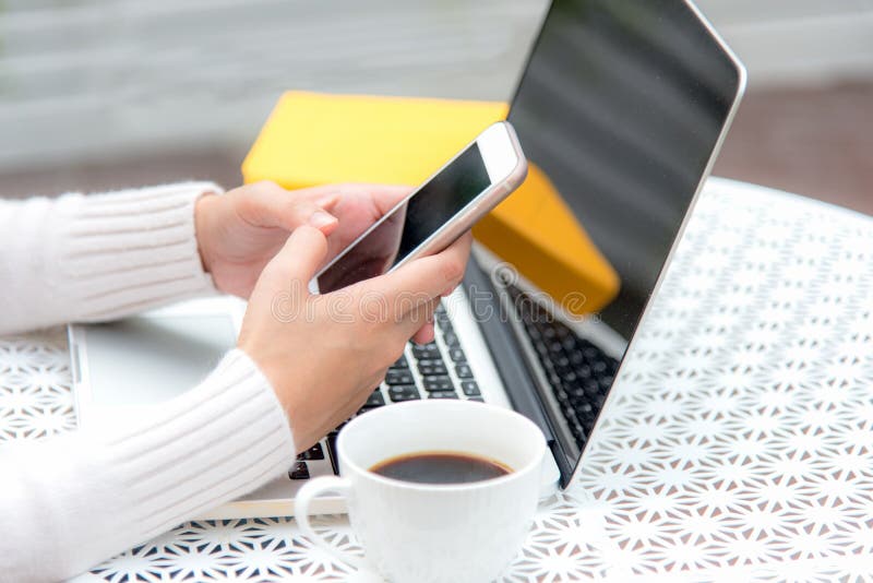 Close up hand women play smart phone for sale online. Work space relaxing chill out work for office and design laptop. With morning coffee. Business and stock photo Close up hand women play smart phone for sale online. Work space relaxing chill out work for office and design laptop. With morning coffee. Business and stock photo