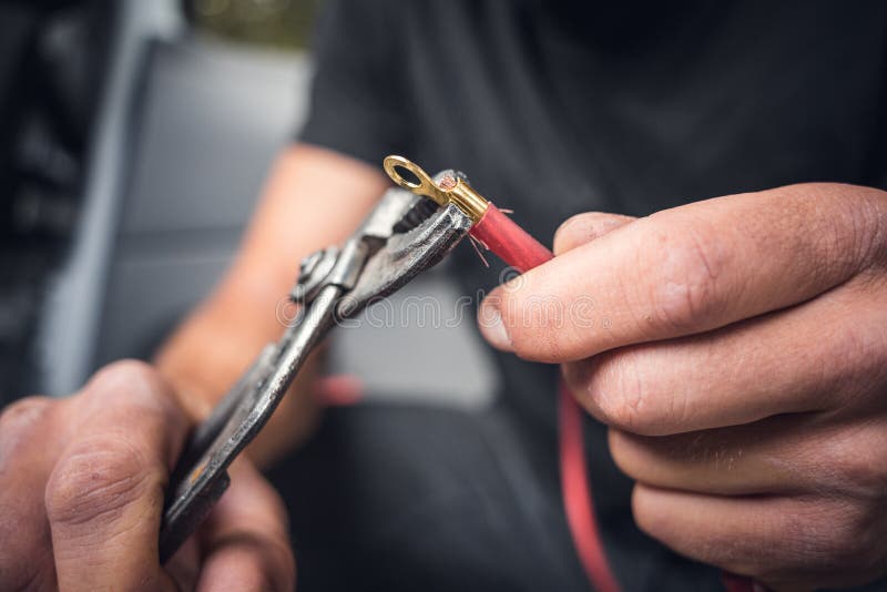 Close up of hands attaching a cable lug to a copper cable royalty free stock image
