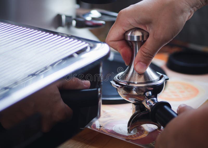 Closeup of Hands Barista Presses Ground Coffee Using a Tamper. the