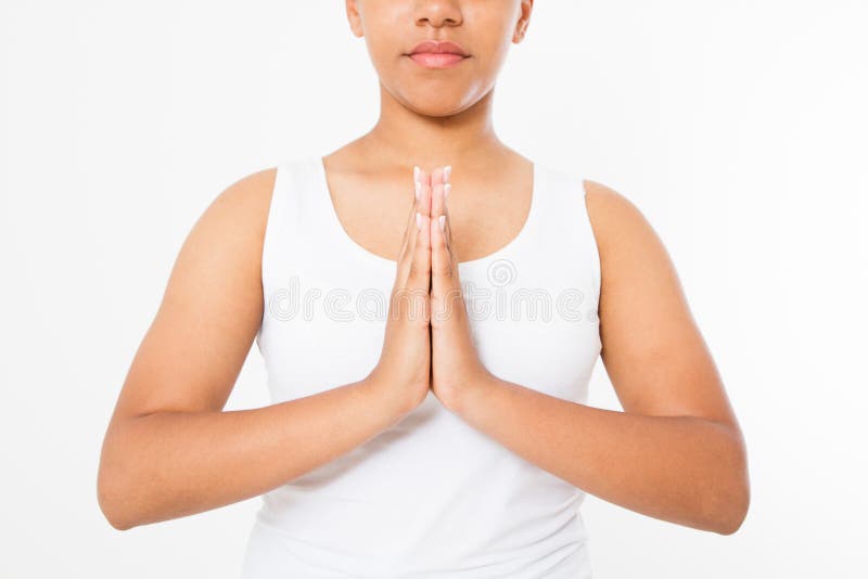 Close-up of hands of black woman in white clothes meditating indoors, focus on arms in Namaste gesture.Mock up. Copy space. Template. Blank