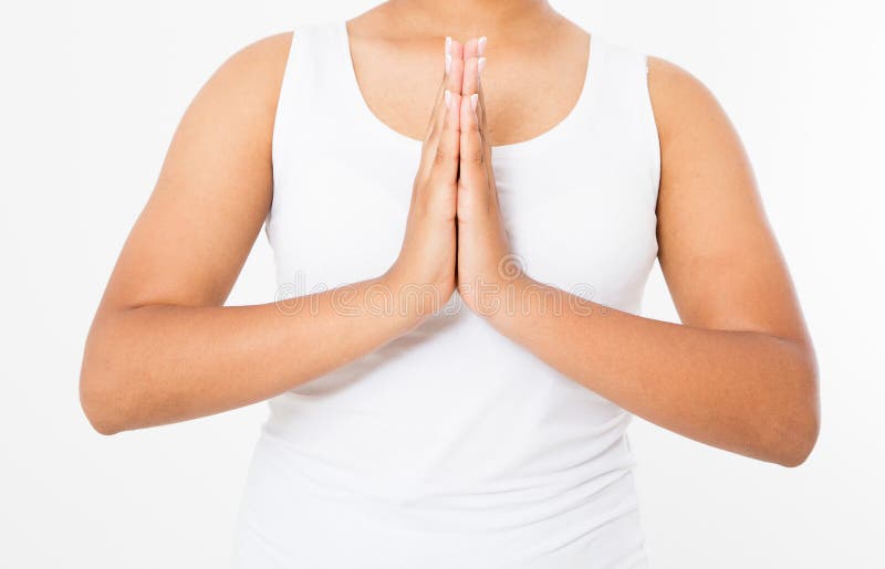 Close-up of hands of black woman in white clothes meditating indoors, focus on arms in Namaste gesture.Mock up. Copy space. Template. Blank