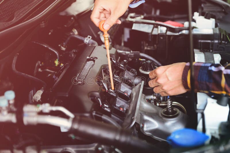 Close up hands checking lube oil level of car engine from deep-stick for service and maintenance concept vintage tone stock photo Close up hands checking lube oil level of car engine from deep-stick for service and maintenance concept vintage tone stock photo