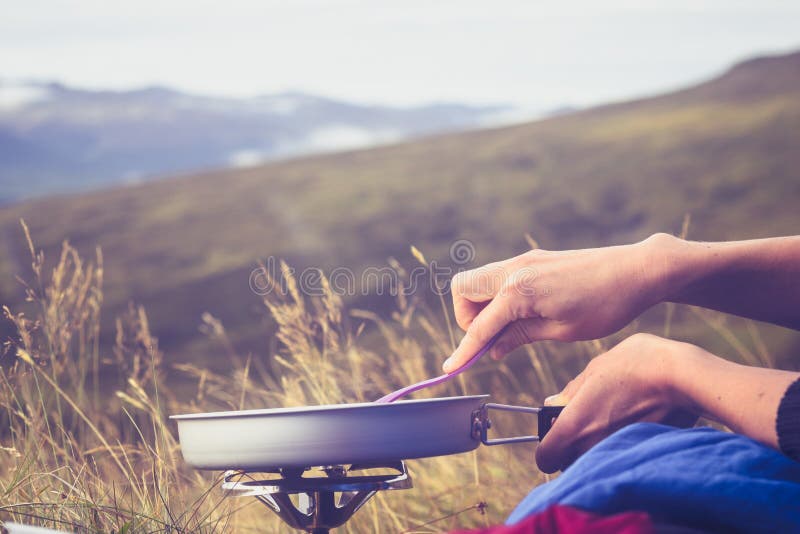 Close up on hands cooking on portable stove in the wild royalty free stock photos Close up on hands cooking on portable stove in the wild royalty free stock photos
