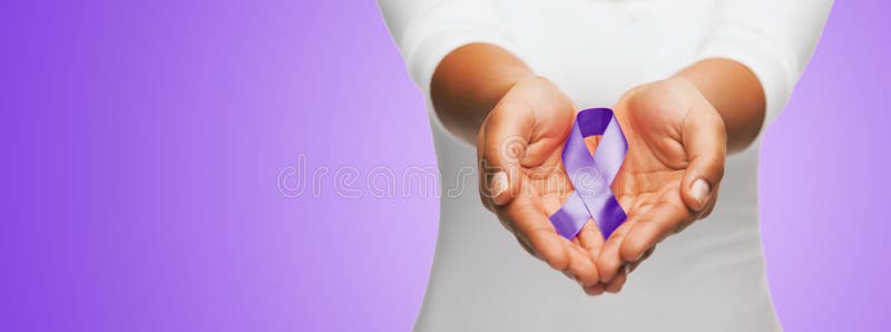 Close up of hands holding purple awareness ribbon