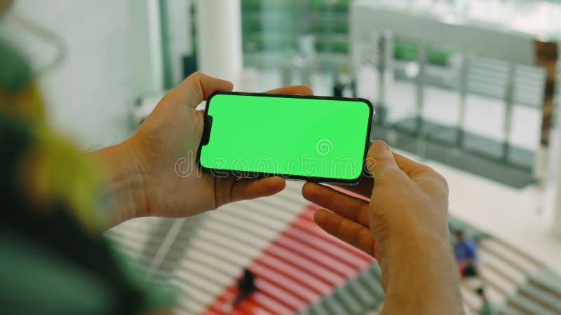 Man hands holding smartphone with green screen in horizontal orientation stock video footage