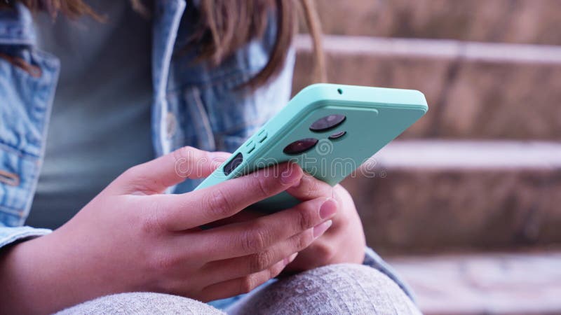 Close-up of hands holding a turquoise smartphone outdoors stock video footage