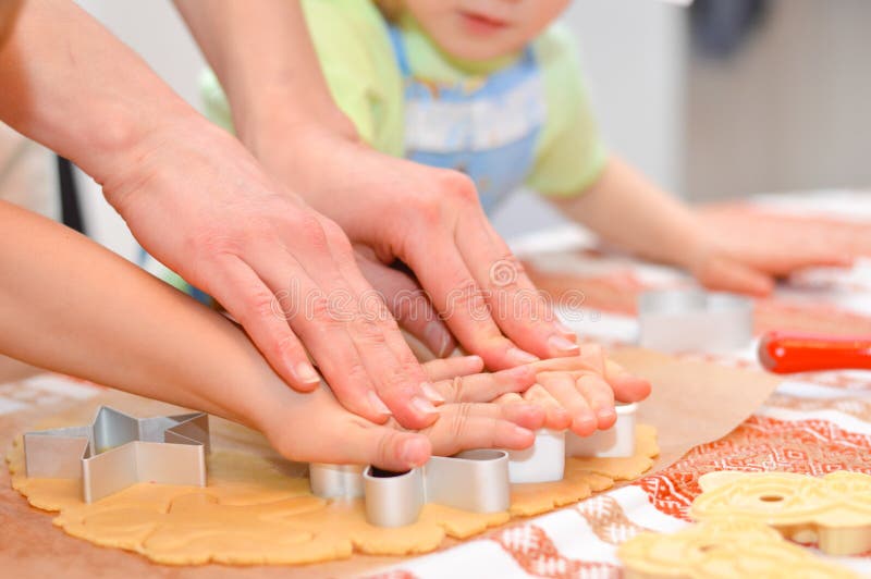 Close up on hands making the gingerbread cookies with mother help