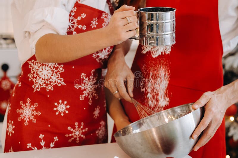 Close-up of hands pouring flour into a container for stirring dough stock images
