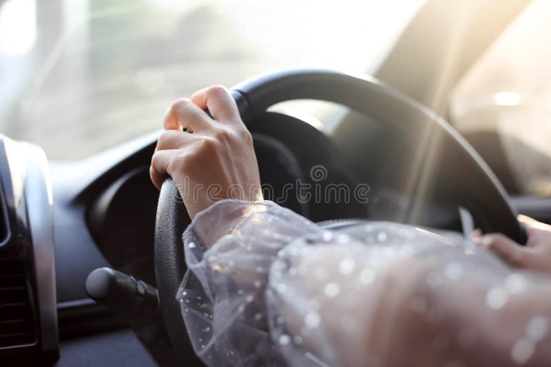 Close-up of hands on steering wheel while driving a car stock images Close-up of hands on steering wheel while driving a car stock images