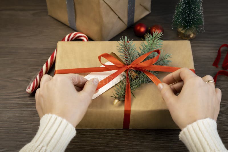 Closeup of Hands Tying Red Ribbon on Gift Box. Stock Photo Image of christmas, celebration