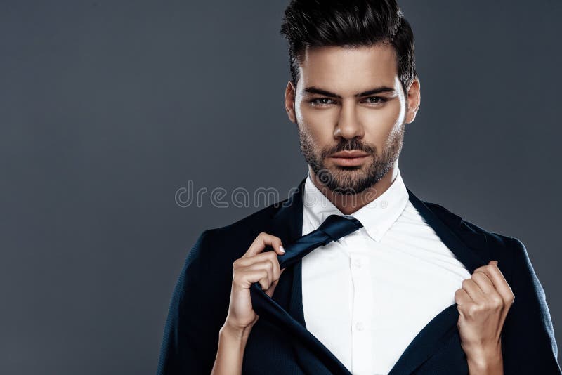 Close-up handsome and successful man in an expensive suit. He is in a white shirt with a tie.