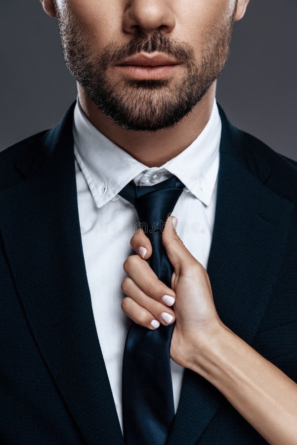 Close-up handsome and successful man in an expensive suit. He is in a white shirt with a tie.