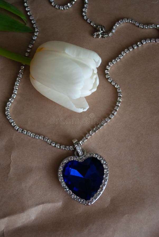 close up heart ocean necklace white tulips bouquet craft paper titanic blue diamond shaped 292760969
