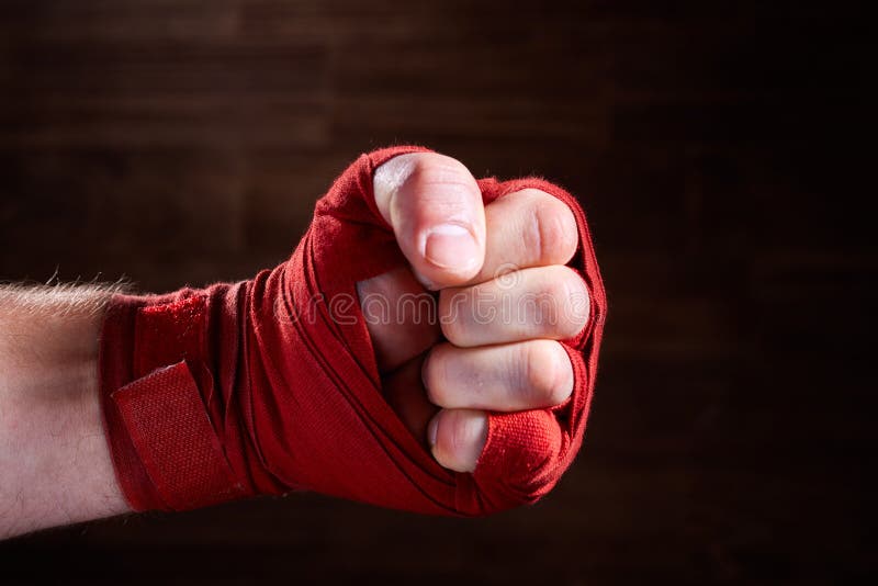 Close Up Image of Fist of a Boxer with Red Bandage Against Brown