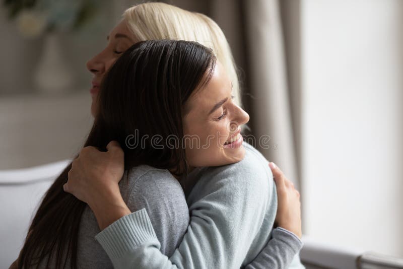 Close up image grown up daughter hugging elderly mother