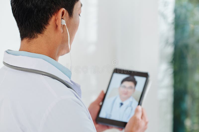 Physician making video call stock photo