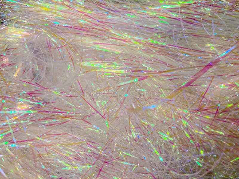 Close-up image of shimmering, light pink and yellow shredded material in abstract pattern, emphasizing texture and color royalty free stock photo